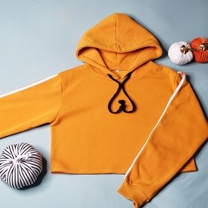 Orange fleece lined crop hoodie with long sleeved stripes. Women's size Medium.